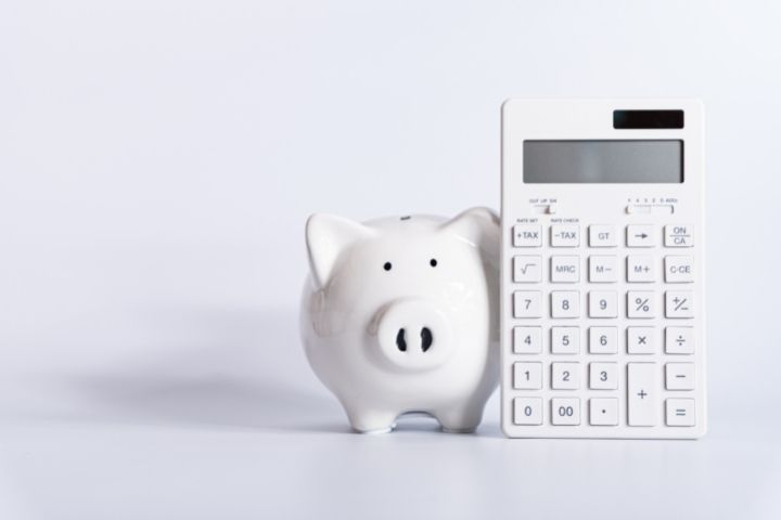 白い豚の貯金箱と電卓の画像