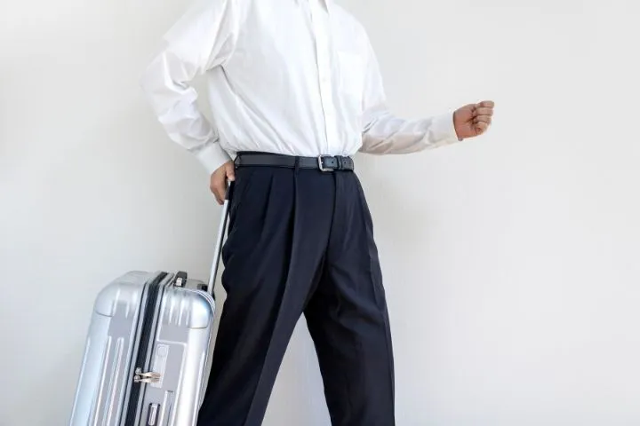 キャリーケースを片手に歩く男性のイメージ