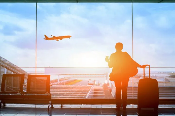 空港で飛行機を眺める後ろ姿の画像