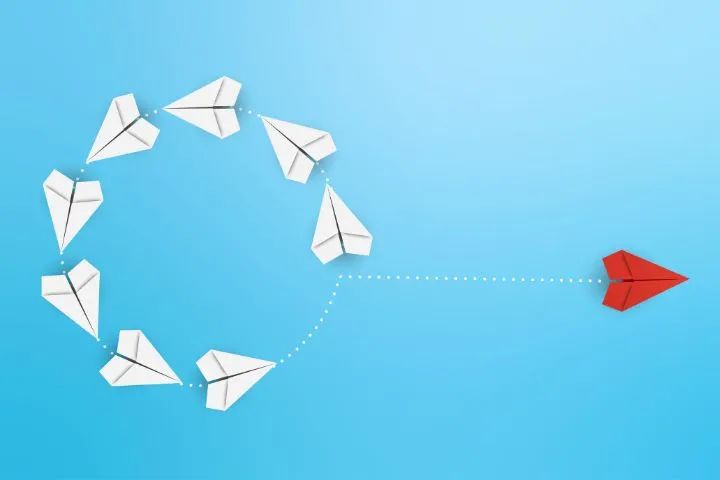 弧を描く6つの紙飛行機のイメージ