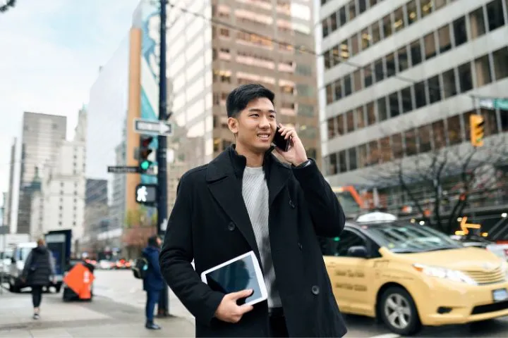 タブレットを持ちながら電話をしている男性のイメージ