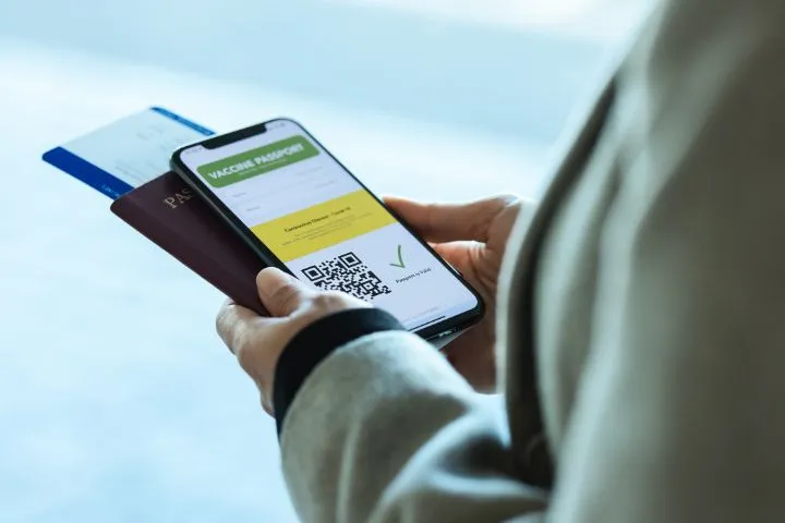 スマホでワクチンの接種証明の画面を見る人の画像