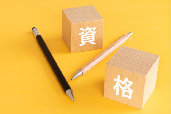 資格と書かれた木製ブロックとペンの画像