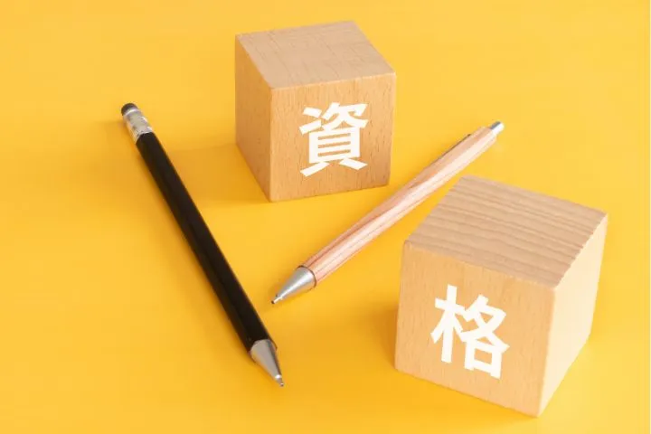 資格と書かれた木製ブロックとペンの画像