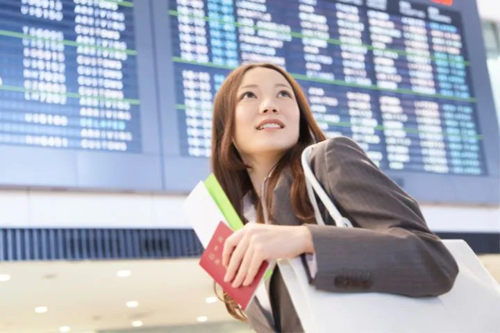 空港にいるパスポートを持った女性