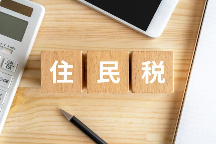 住民税と書かれたブロックとスマホとペンの画像