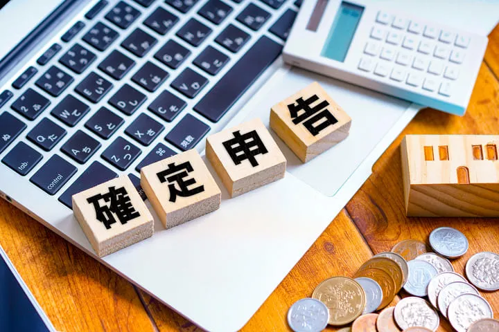 確定申告と書かれたブロックとパソコンと電卓