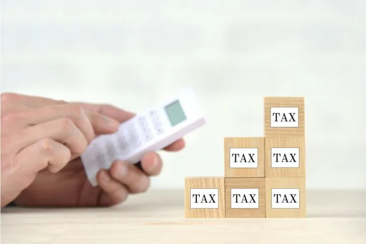 電卓とTAXと書かれた積木が積まれている様子