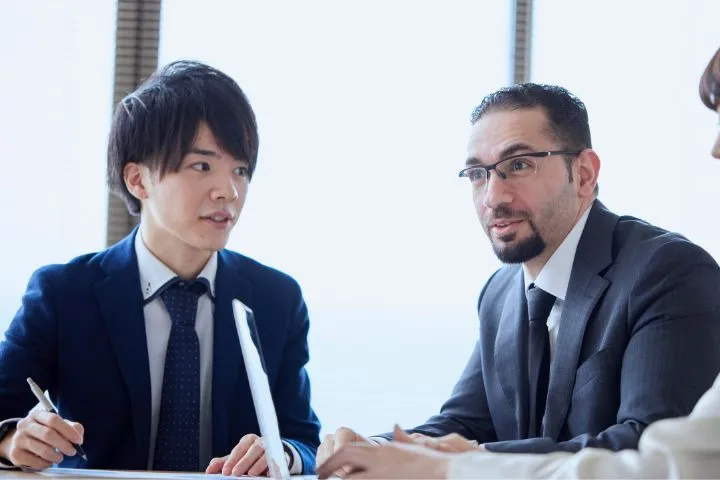 会議に参加する日本人男性と外国人男性のイメージ
