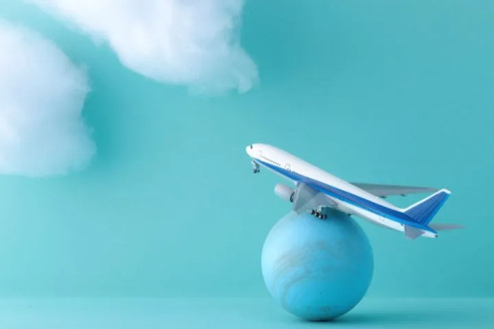 地球儀の上に飛行機の模型が乗っているイメージ