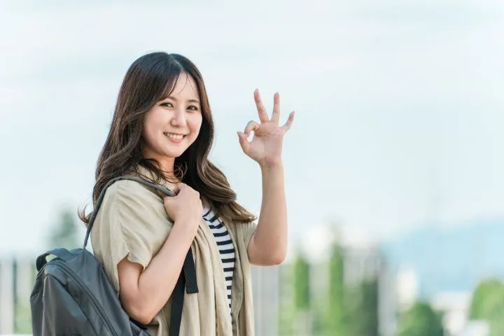 若い女性が笑顔でOKマークを作っている様子