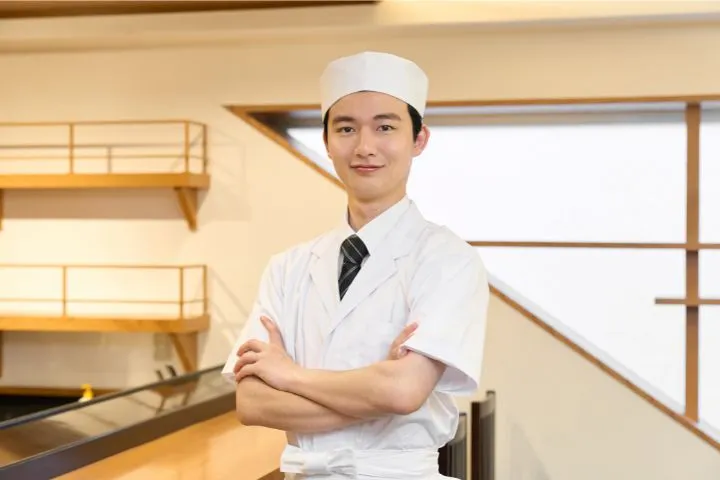 腕を組んでほほ笑む寿司職人の画像