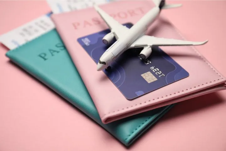 クレジットカードとパスポートと飛行機の模型の画像