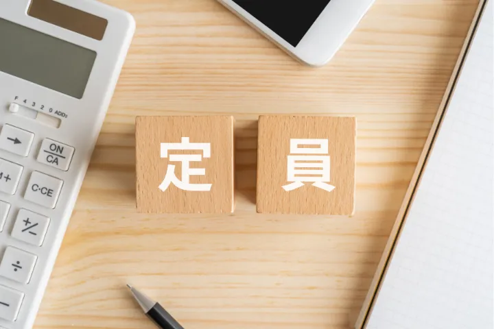 机の上に定員と書かれたブロックが並んでいるイメージ