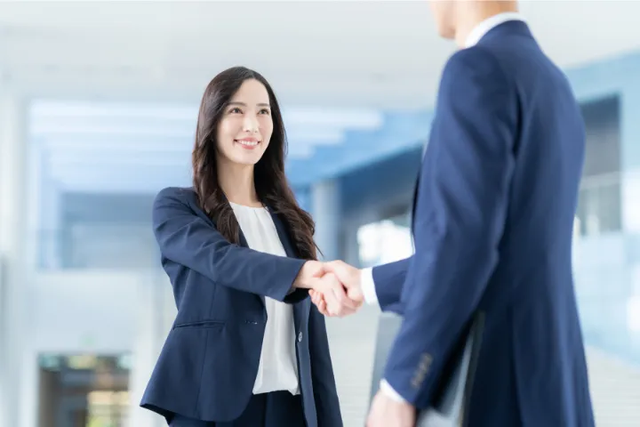 握手をするスーツ姿の女性のイメージ