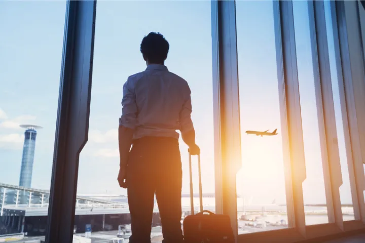 空港から飛行機を見る男性のイメージ