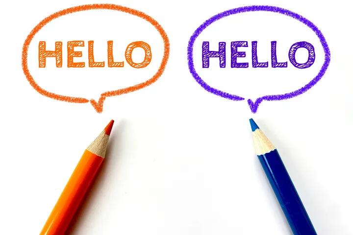 赤と青の色鉛筆でHELLOと書かれた文字のイメージ