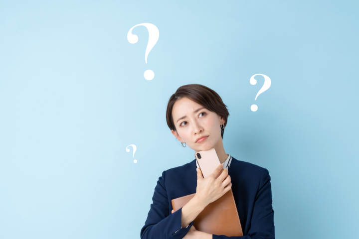 スマホを持って考える日本人女性の画像