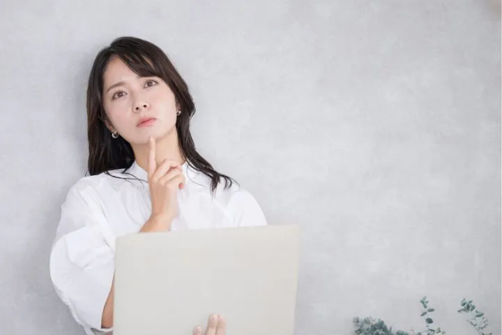 考える女子大学生の画像