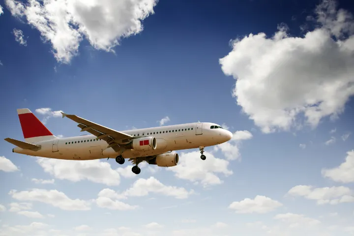 青空を飛ぶ飛行機の画像