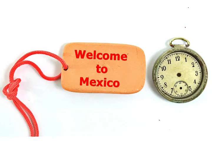 ようこそメキシコへと英語で書かれたタグと針のない時計が置かれた画像