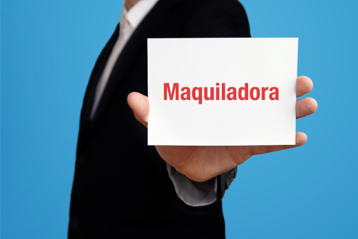 赤字でMaquiladoraと書かれた紙を持っているスーツの男性のイメージ