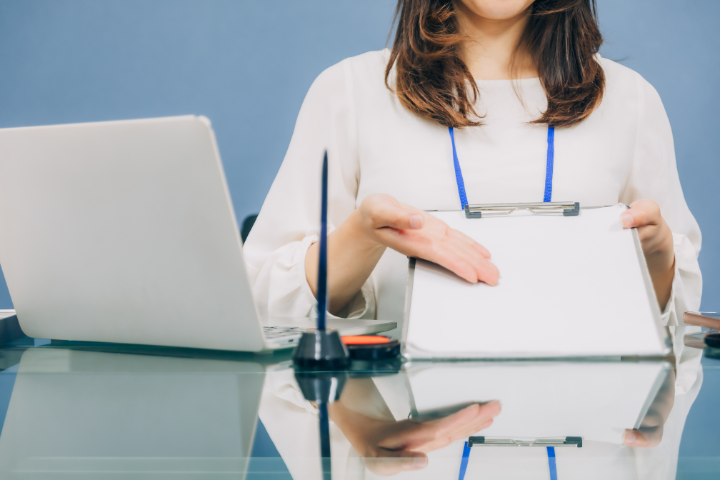窓口で書類の案内をしている女性のイメージ