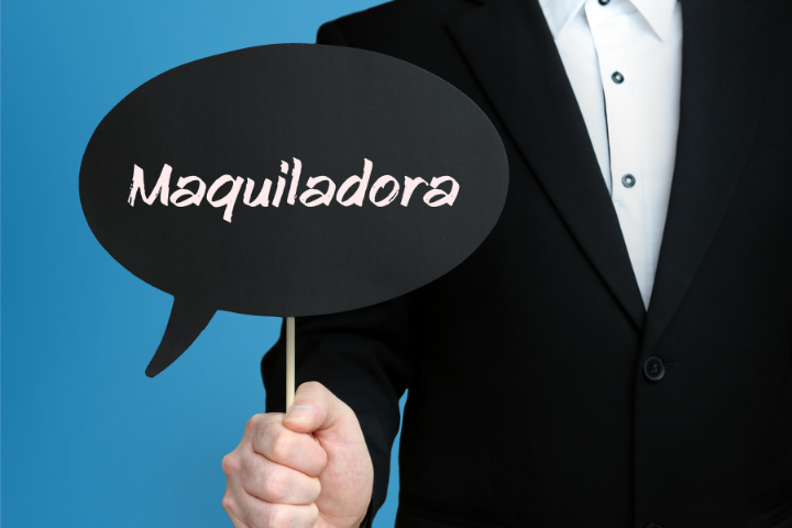 黒の背景に白字でMaquiladoraと書かれた吹き出し板を持っている人のイメージ