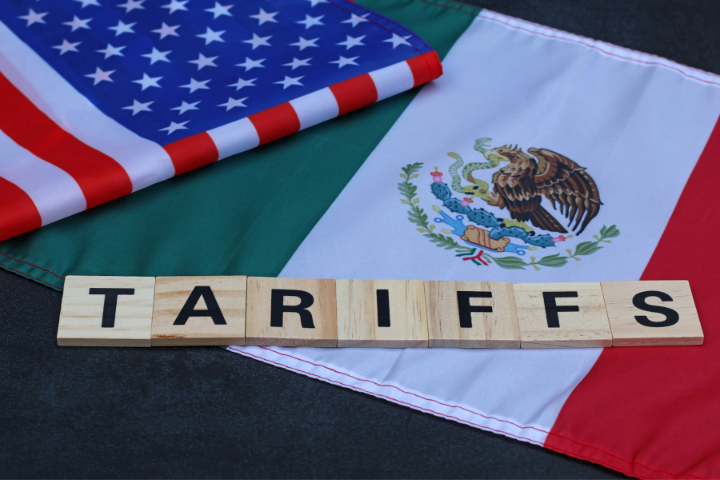 アメリカとメキシコの旗の上にTARIFFSと書かれたブロックが置いてあるイメージ