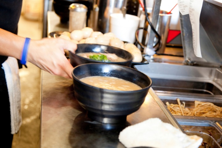 厨房でラーメンを作っている人の手元の画像
