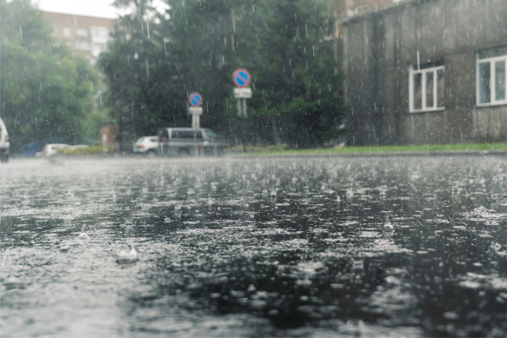 住宅街に大雨が降っているイメージ