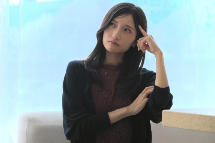 こめかみに指を当てて悩んでる女性のイメージ