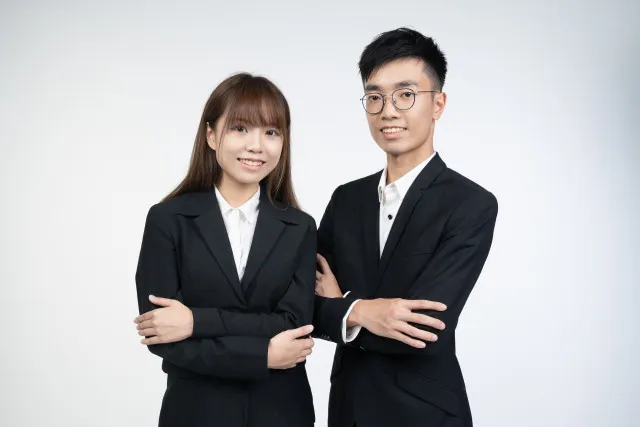 スーツ姿のアジア人男女がほほ笑んでいる画像
