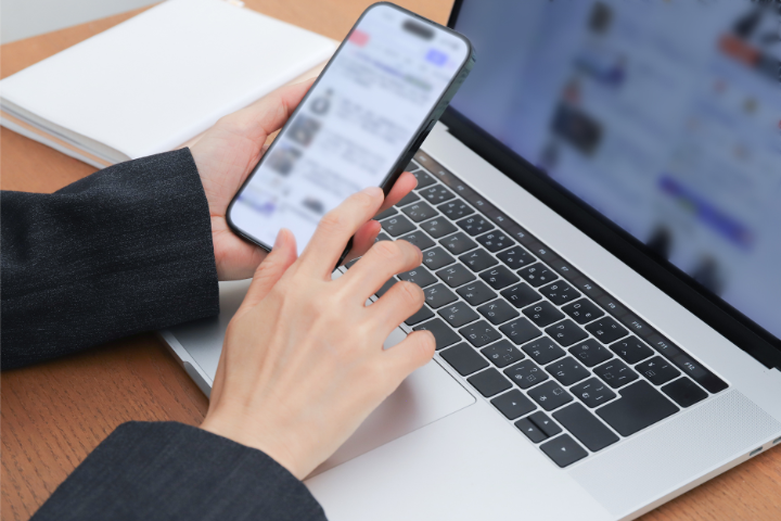 ノートパソコンとスマホで調べものをしている人のイメージ