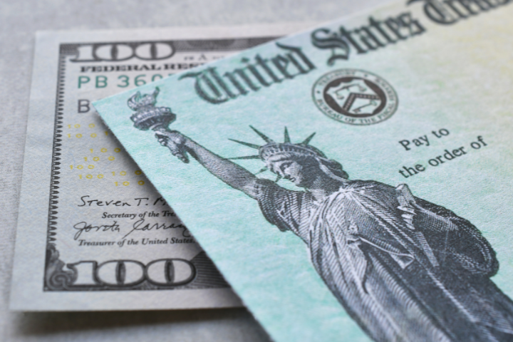 アメリカ合衆国財務省発行の小切手と100ドル紙幣の画像