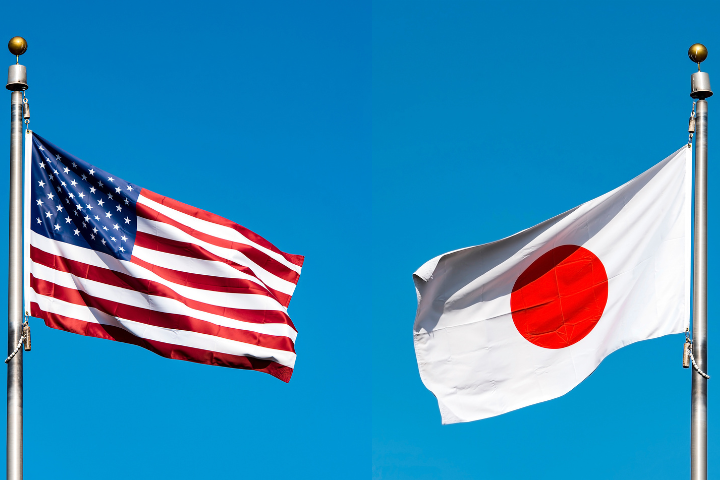 青空を背景に日本国旗とアメリカ国旗が風にはためいている画像