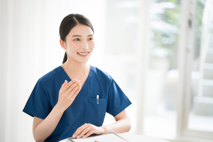 紺色のスクラブを着た笑顔の日本人女性の画像