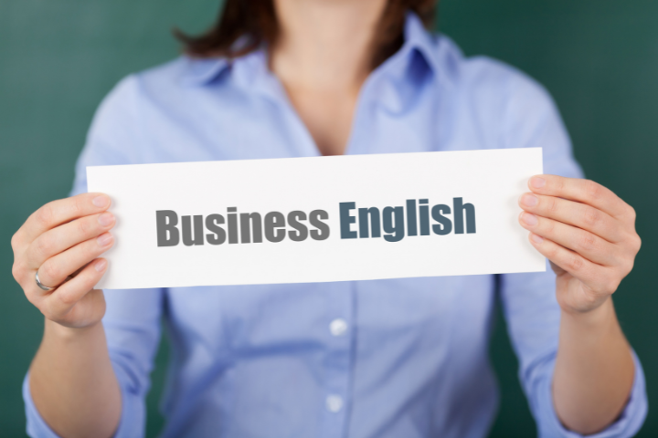 business englishと書かれた紙を持った女性の画像