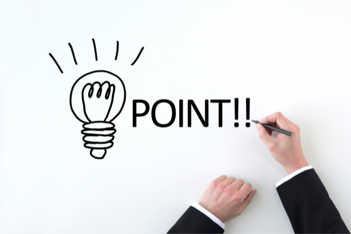 豆電球とPOINT!!の文字を書くスーツ姿の男性の手元の画像